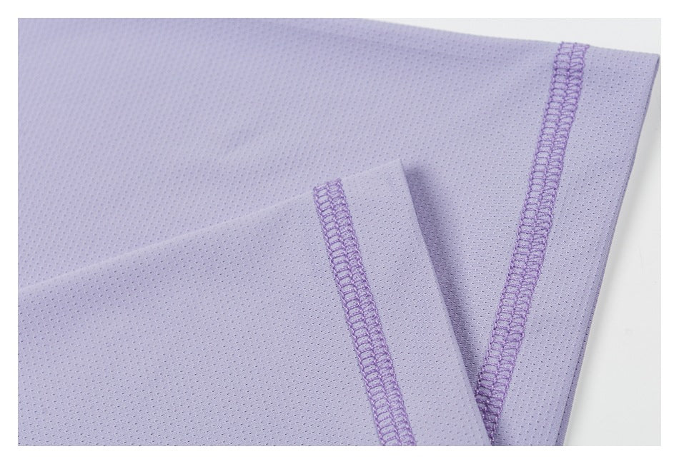 Close-up of lavender perforated fabric with a folded edge and purple overlock stitching.