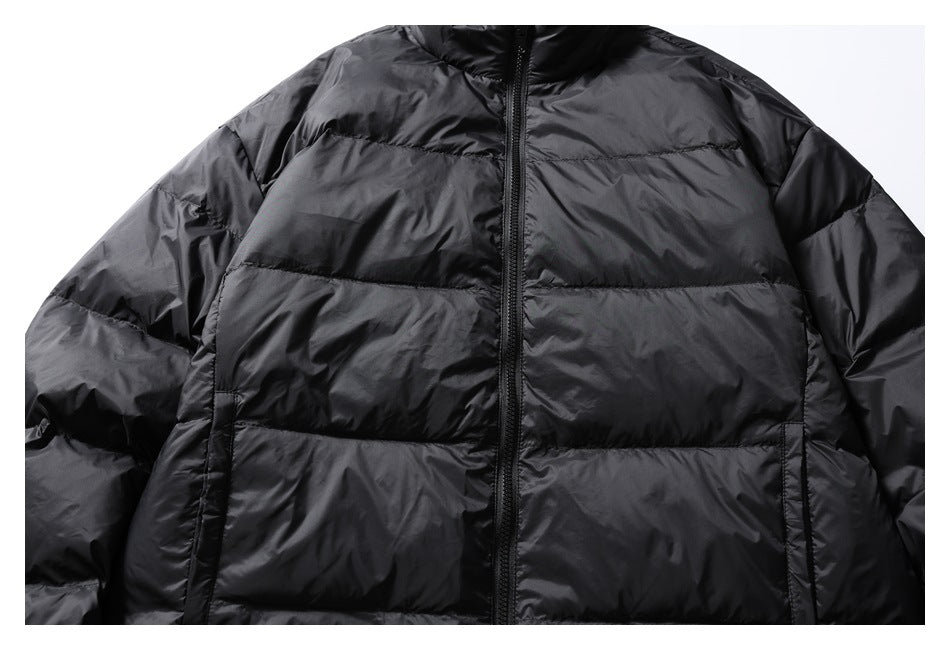 Close-up of a black quilted puffer jacket front with a center zipper and horizontal stitching.