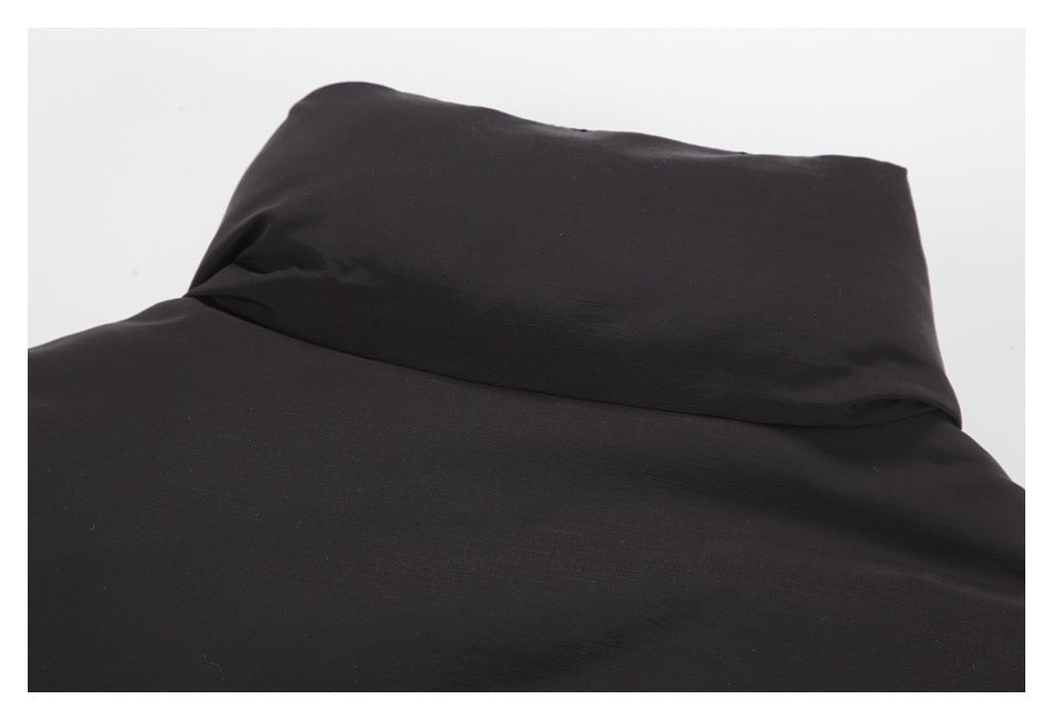 Close-up of the black jacket’s raised collar and outer fabric.