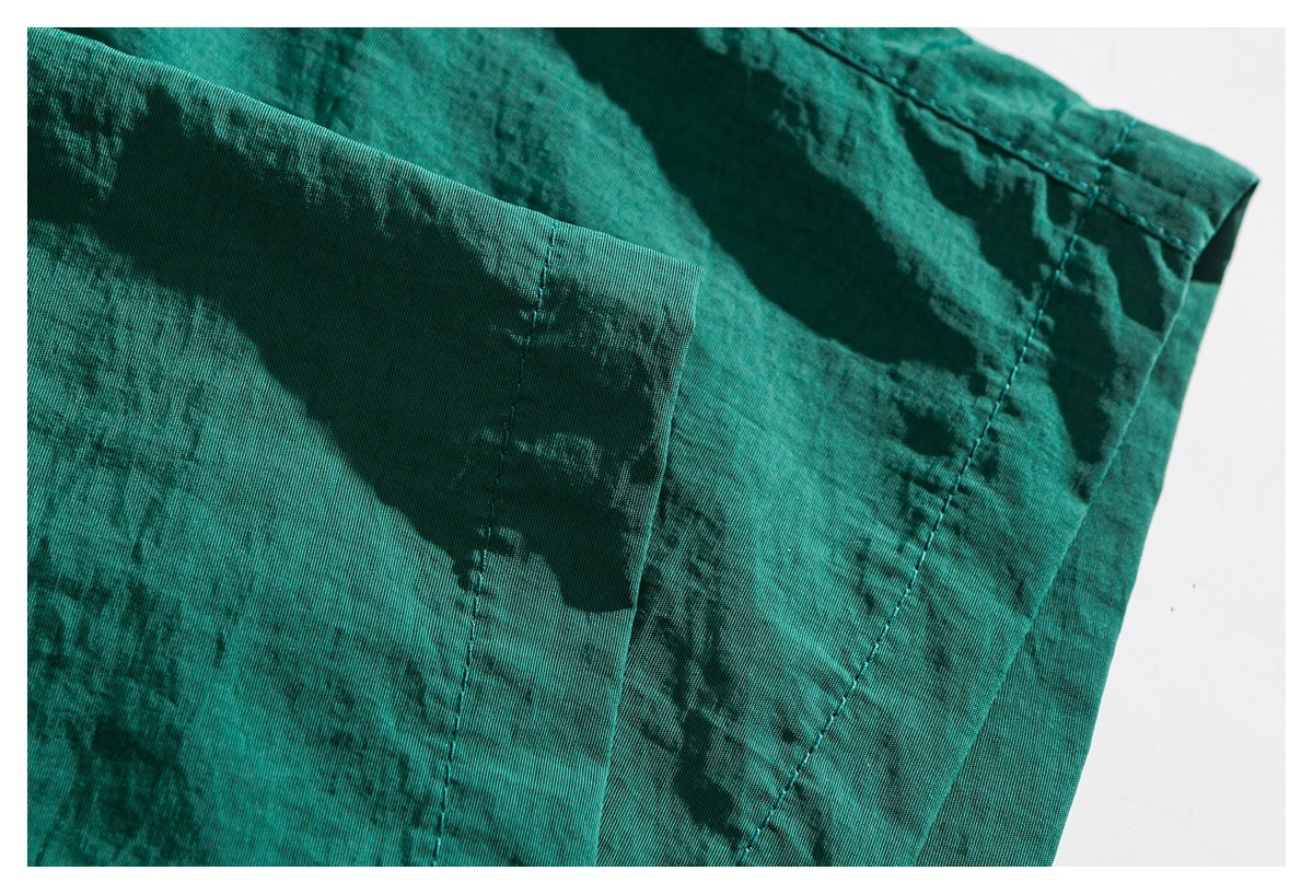 Close-up of teal shorts showing stitched seams and a narrow fabric panel.