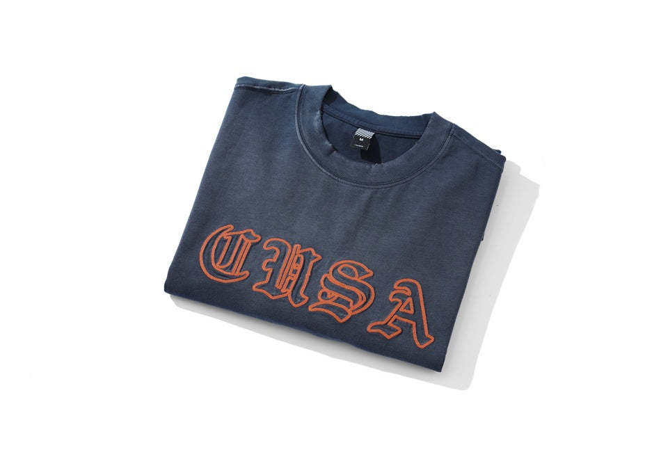 Folded navy long-sleeve shirt showing orange outlined lettering across the chest.