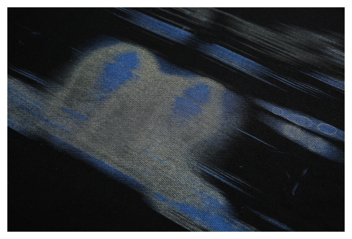 Close-up of black fabric with blue-gray streaks and a subtle textured surface.