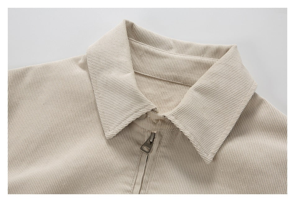 Close-up of the cream corduroy jacket's pointed collar and front zipper.