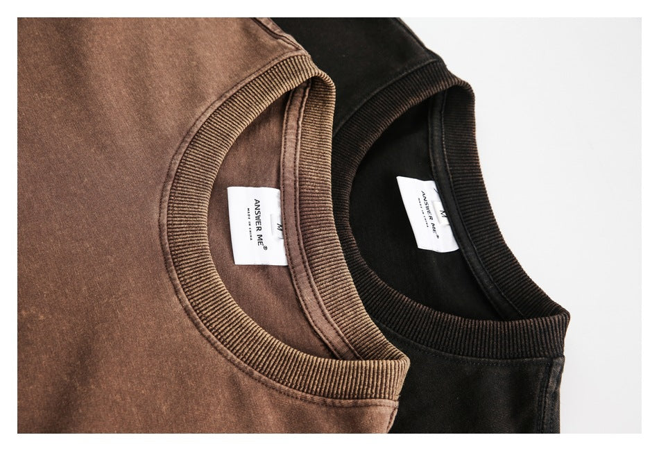 Close-up of the ribbed collars and sewn-in labels on brown and black T-shirts.