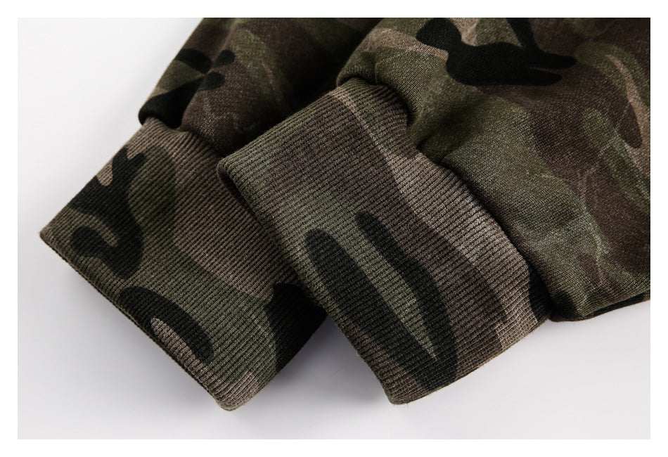 Close-up of ribbed cuffs on a dark green, brown, and black camouflage garment.