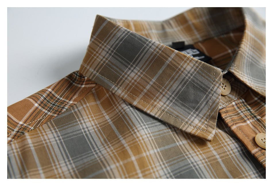Close-up of the shirt's pointed collar and plaid pattern in brown, gray and cream.