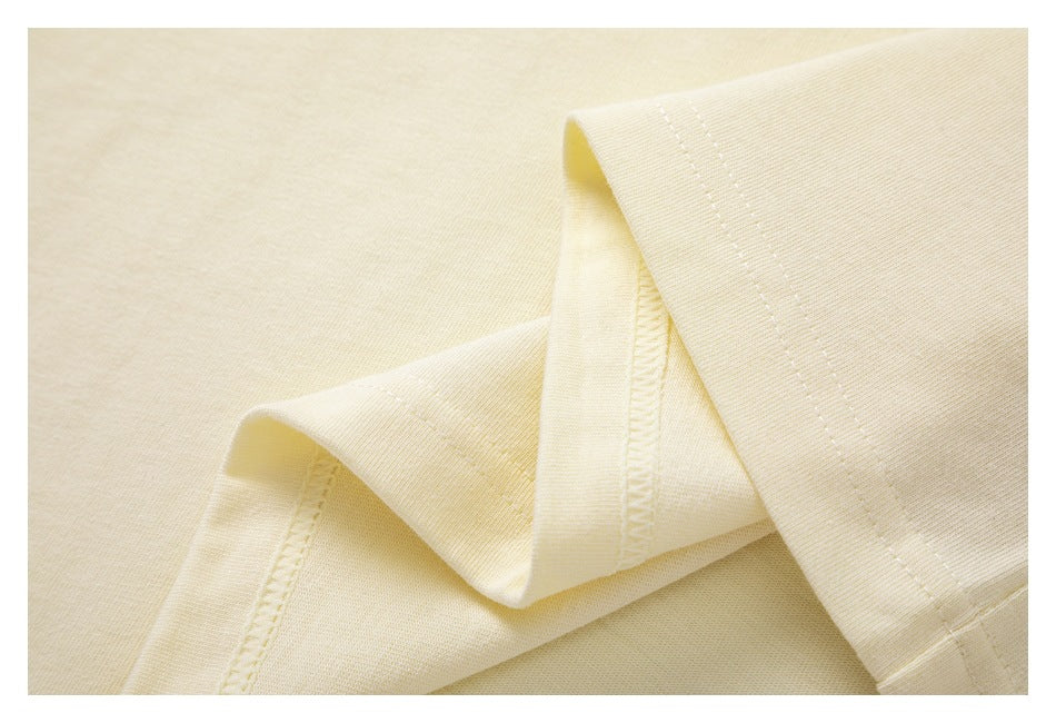 Close-up of ivory knit fabric folded to show a stitched edge and seam.