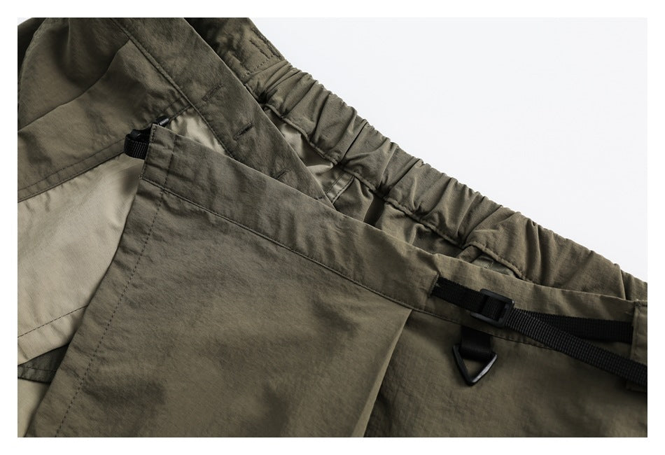 Close-up of the olive skirt's gathered waistband, inner panel, pocket edge, and adjustable black strap.