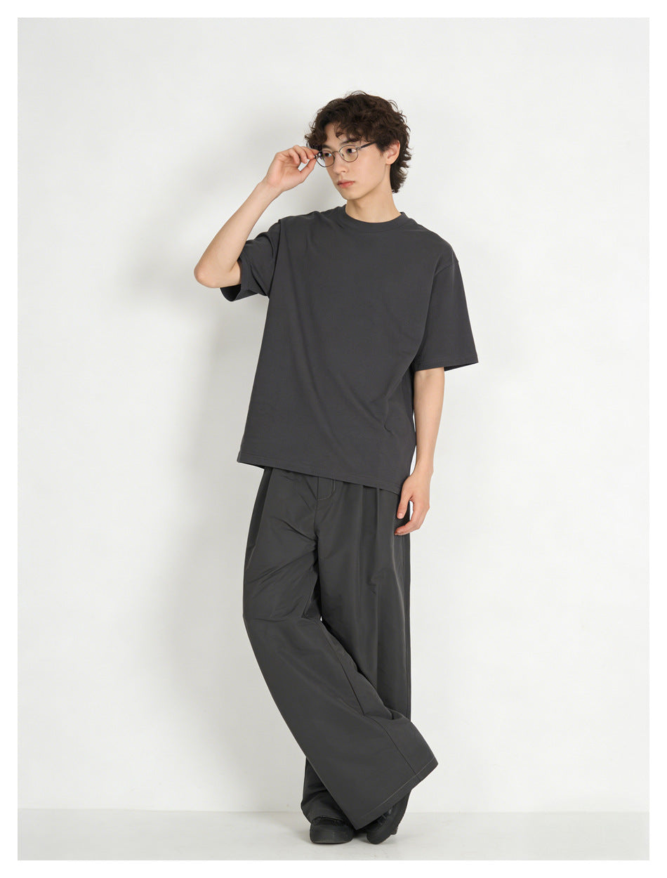 Full-length model wearing a charcoal oversized crew-neck T-shirt with matching wide-leg pants.