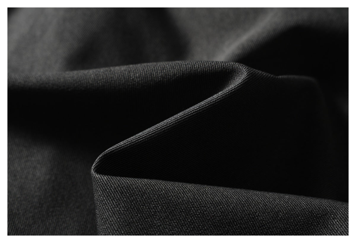 Close-up of folded black fabric showing its fine ribbed texture.