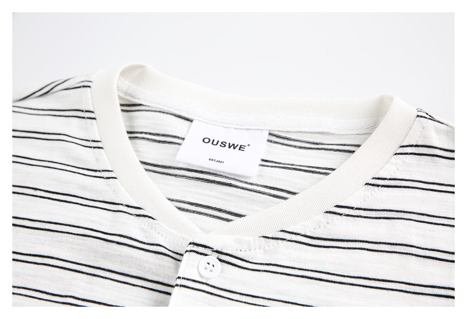 Close-up of the white striped top's V-neck, button placket and sewn neck label.
