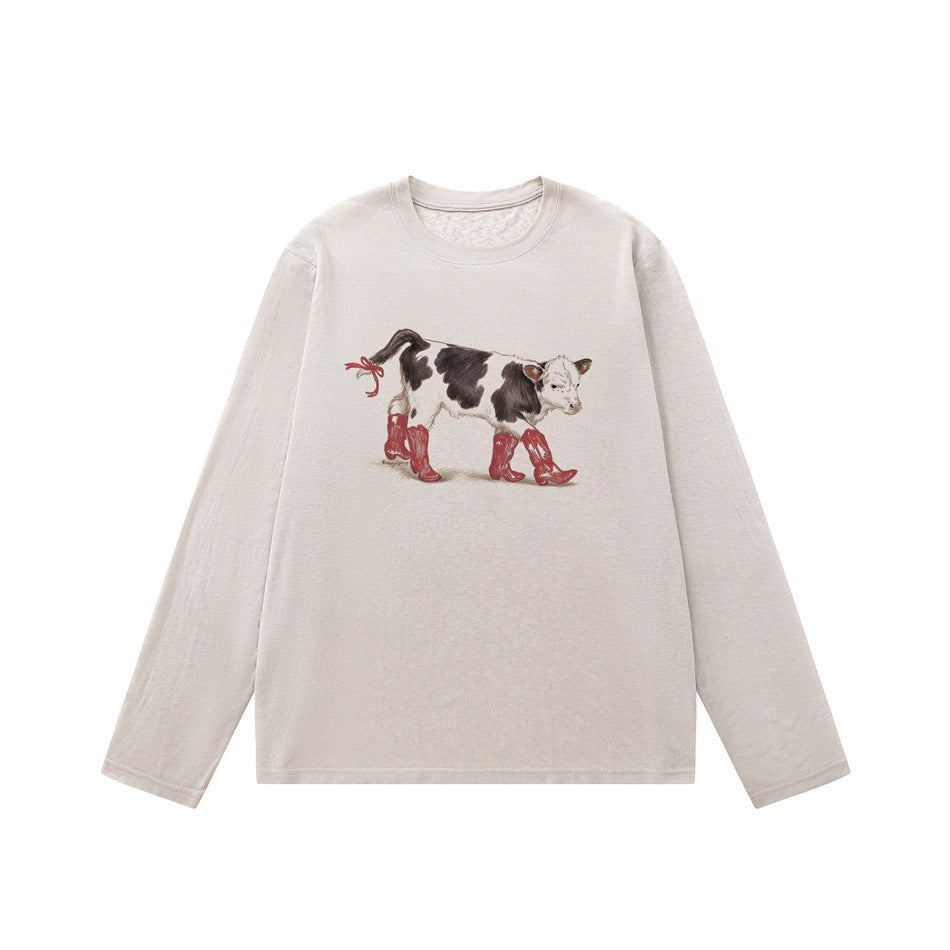 Light beige-pink long-sleeve crew-neck tee with a calf in red cowboy boots graphic, flat lay front view