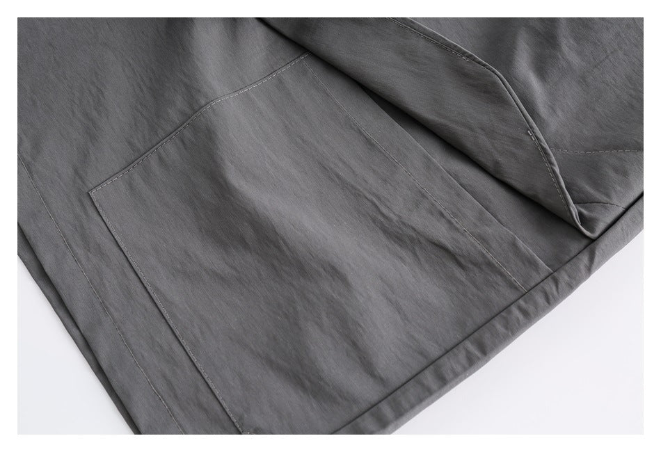 Close-up of gray bottoms showing a stitched patch pocket and hem.