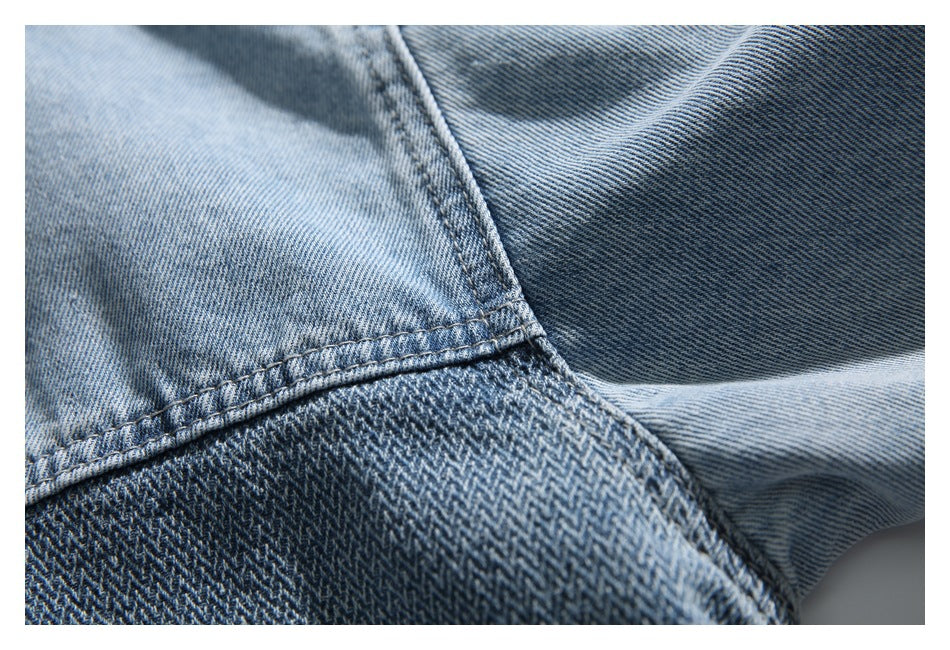 Close-up of blue denim fabric with a curved stitched seam and contrasting diagonal weave.