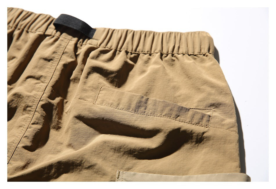 Close-up of a rear pocket and gathered waistband on tan shorts.