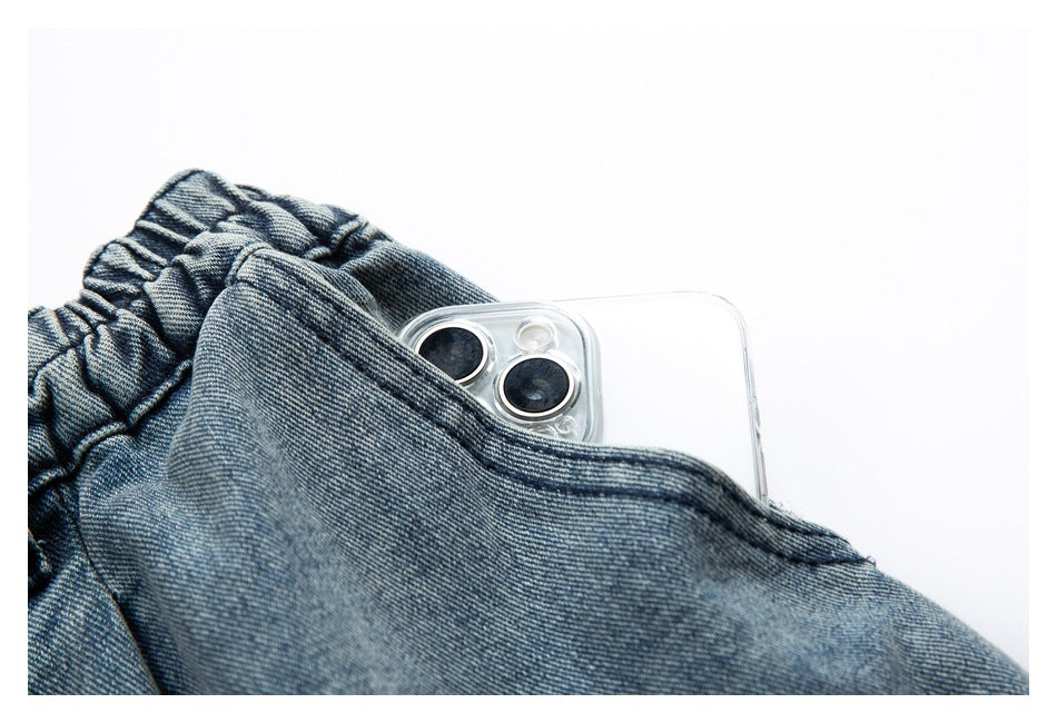 Blue denim pocket shown holding a smartphone, with the elasticized waistband visible.