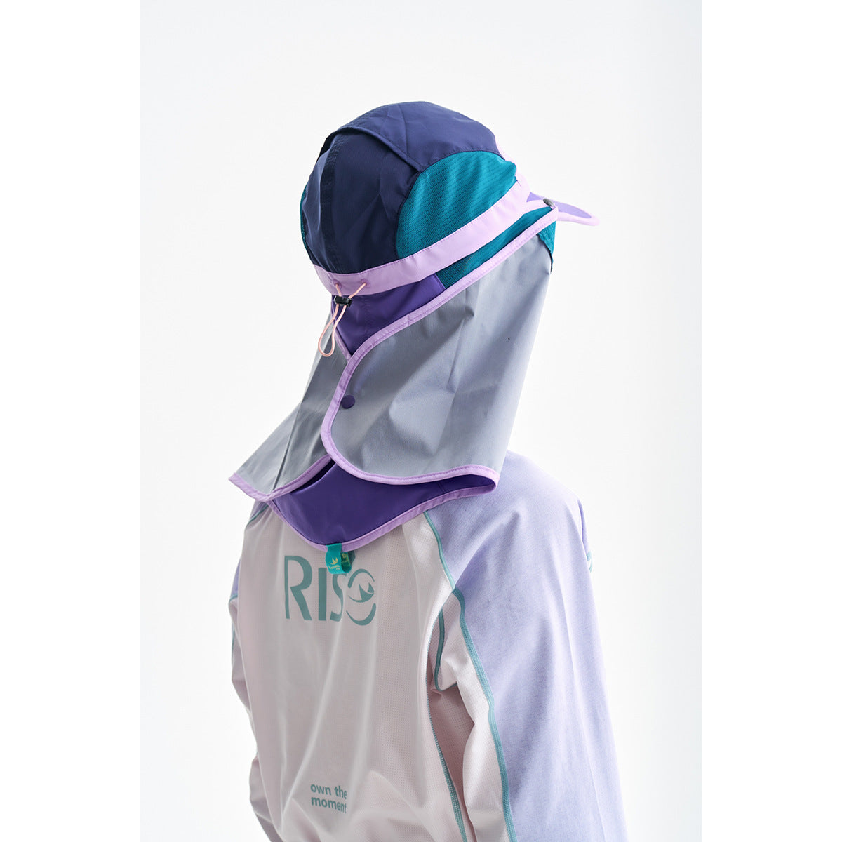 Model wearing a color-block sun-protection hood with face and neck flaps and a white, lavender, and aqua top.