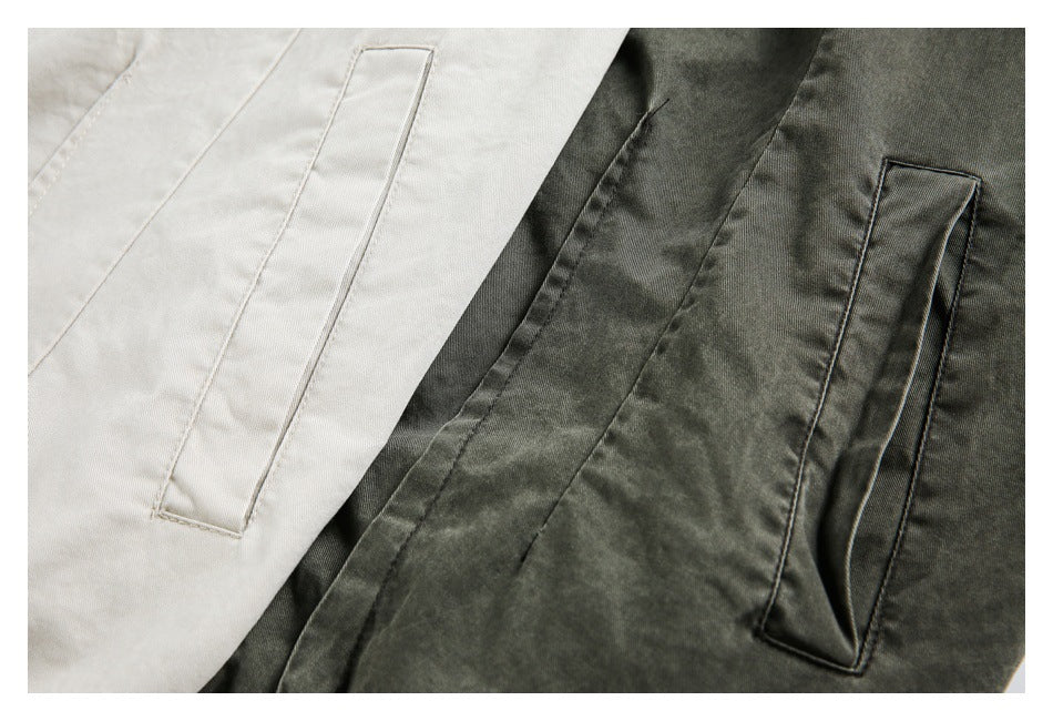 Close-up of cream and charcoal garments, each with a narrow vertical welt pocket.