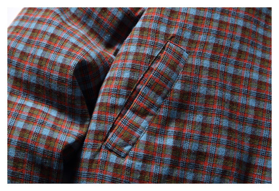 Close-up of a slanted welt pocket on the jacket's blue, rust and brown plaid front.