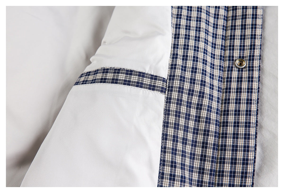 Close-up showing navy-and-white plaid lining beside a pale gray panel and metal snap.