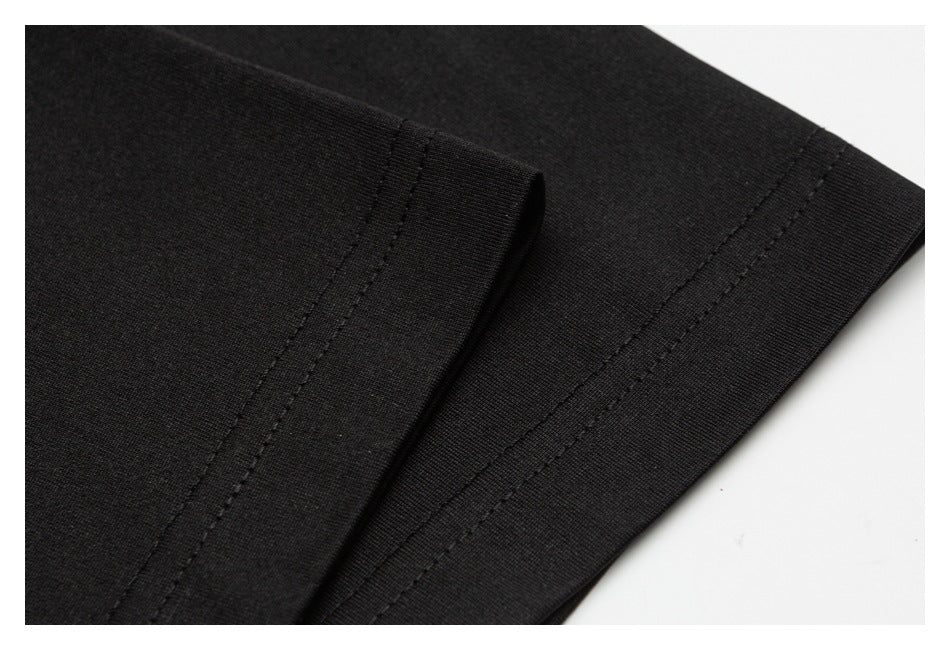 Close-up of a black garment's stitched hem and folded edge.