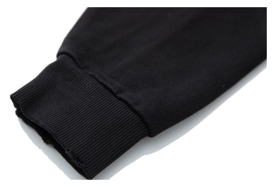 Close-up of a black garment sleeve ending in a wide ribbed cuff against a white background.