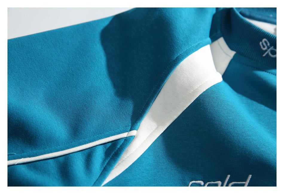 Close-up of a teal top showing its white shoulder and collar inserts and narrow piping.