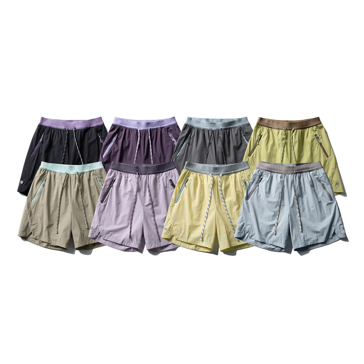Eight pairs of drawstring shorts arranged in two rows in black, purple, gray, olive, beige, lilac, yellow, and pale blue.