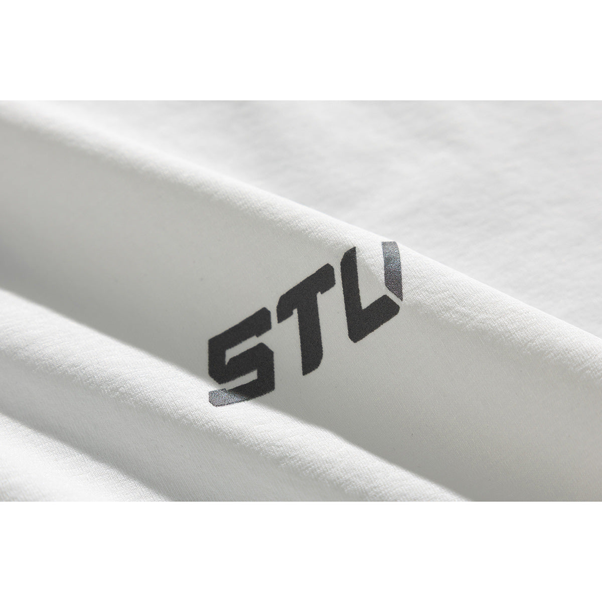 Close-up of a dark stylized logo printed on white T-shirt fabric.