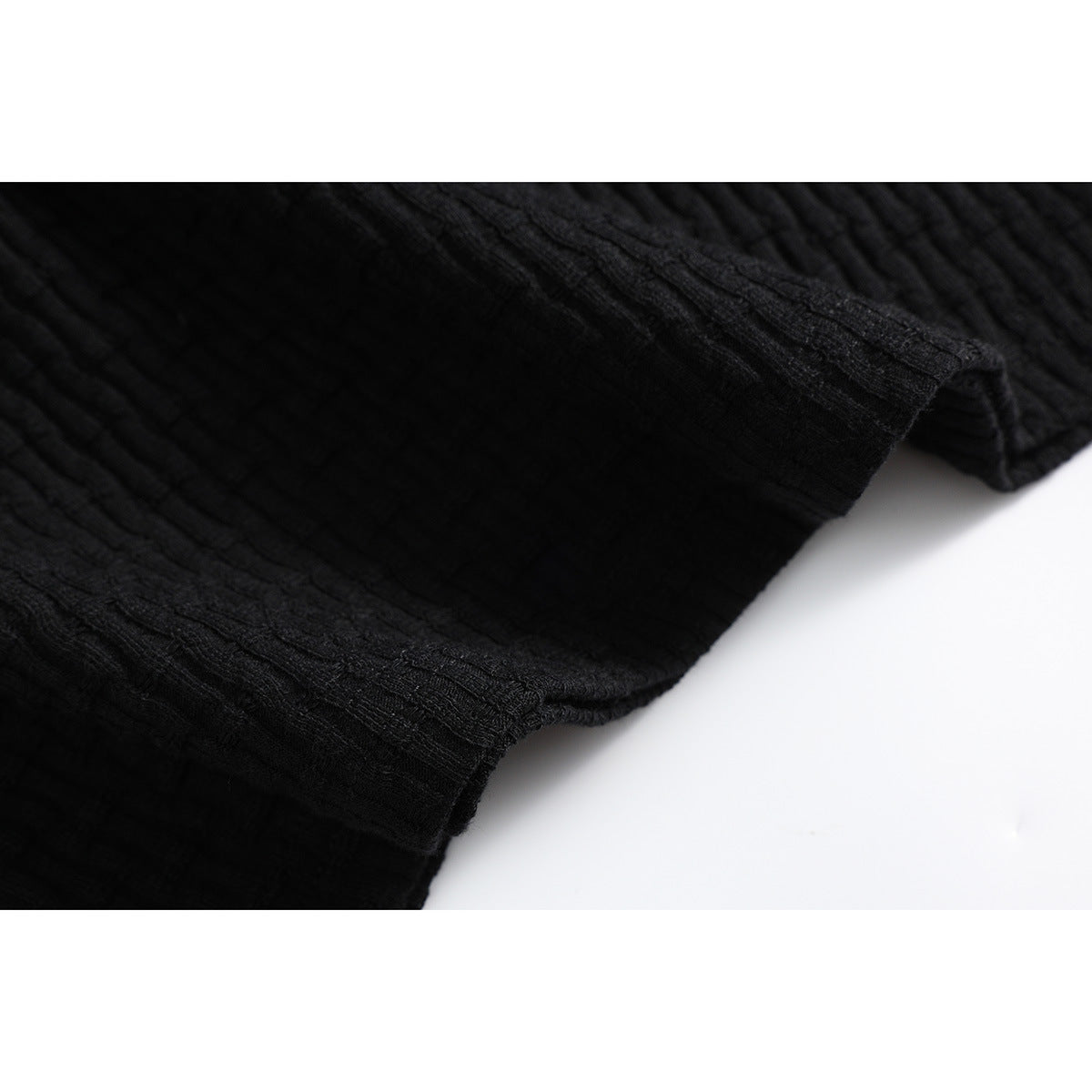 Close-up of the black shirt's stitched edge and ribbed fabric.