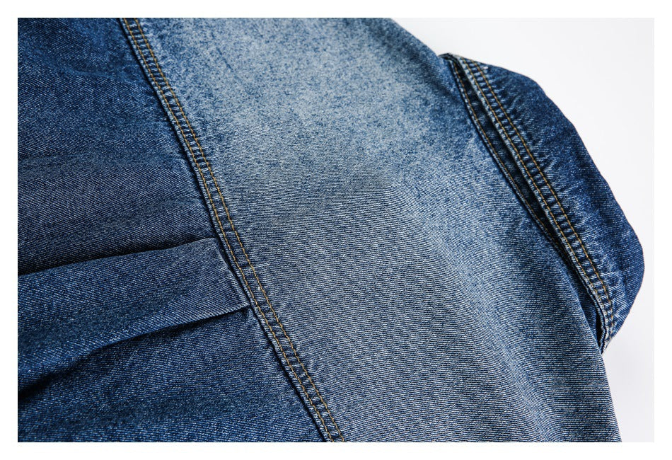 Close-up of blue denim panels with contrasting gold stitching and a folded seam.