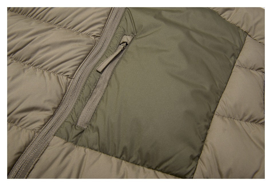 Close-up of the jacket's dark olive chest panel and narrow vertical zip pocket beside the main zipper.