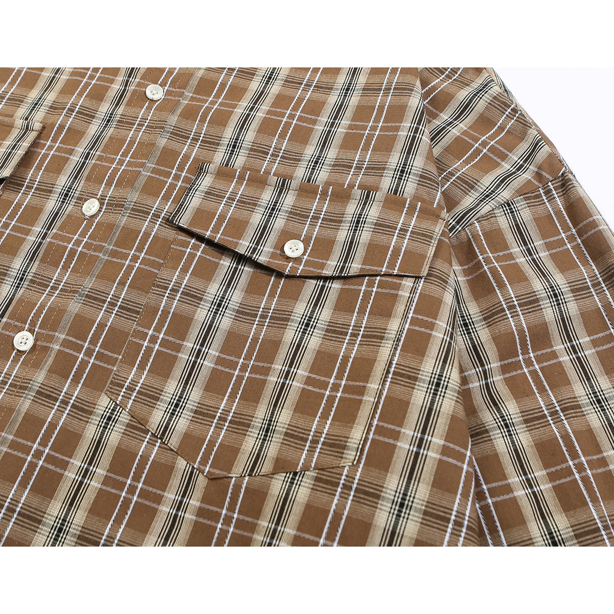 Close-up of a brown plaid shirt showing a buttoned chest pocket, front buttons, and sleeve.
