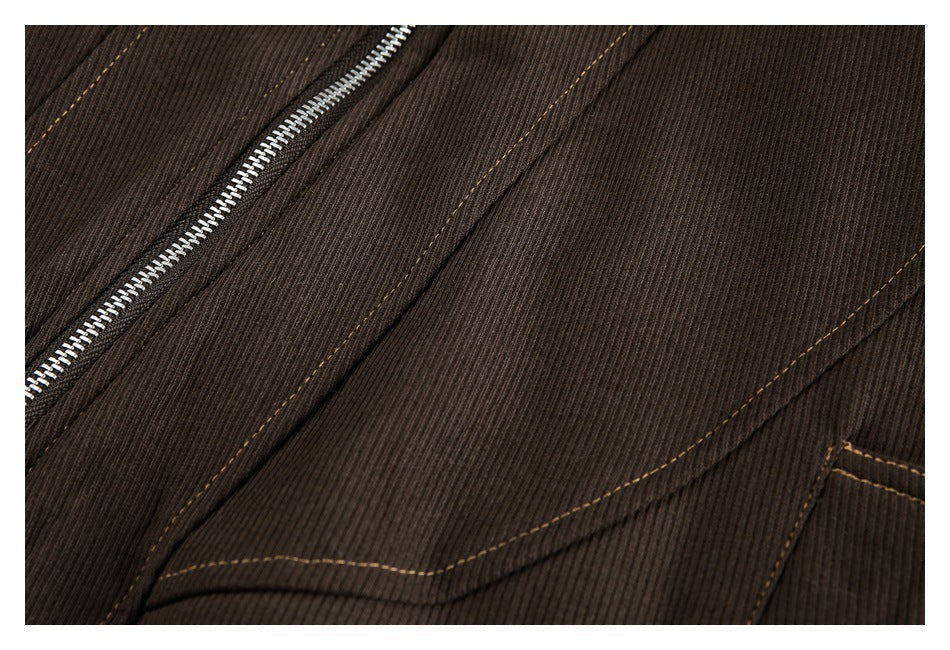 Close-up of a dark brown ribbed garment with a silver zipper and tan contrast stitching.