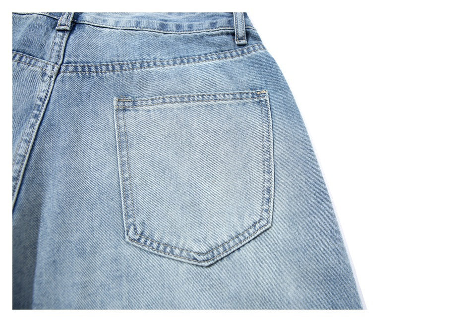 Close-up of a rear pocket and stitching on light blue denim shorts.