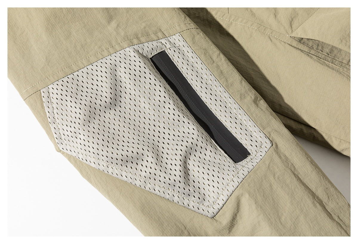 Close-up of a light mesh pocket panel on the khaki jacket, with a dark vertical opening.