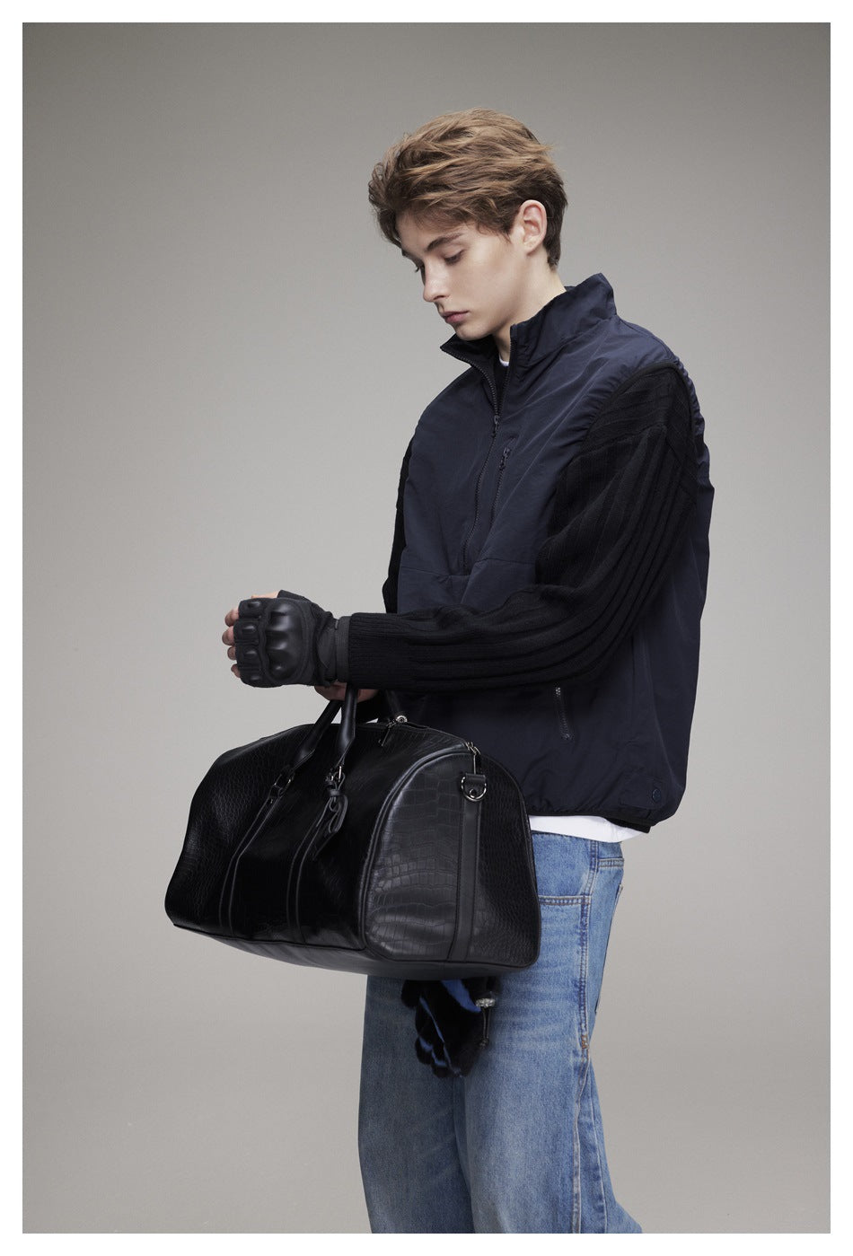 Closer side view of a model wearing a navy quarter-zip pullover with black ribbed sleeves.