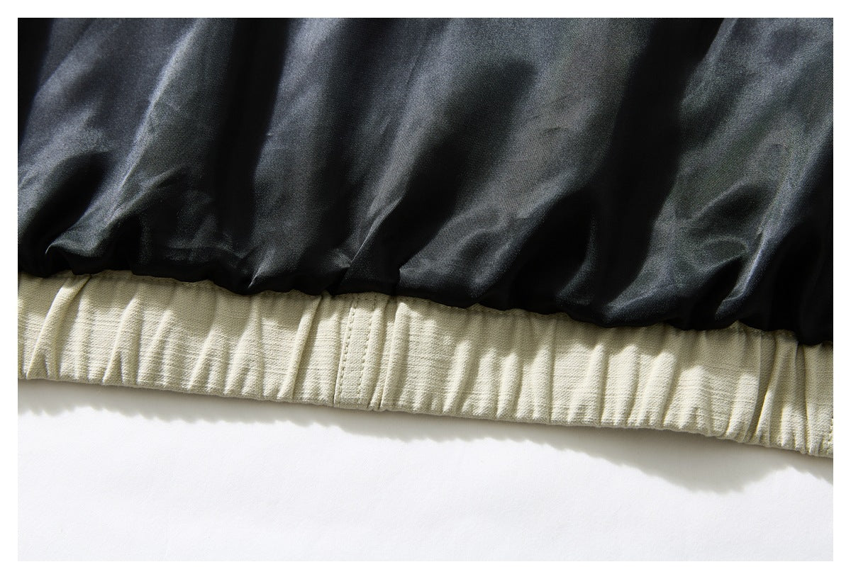Close-up of black inner lining above the gathered ivory jacket hem.