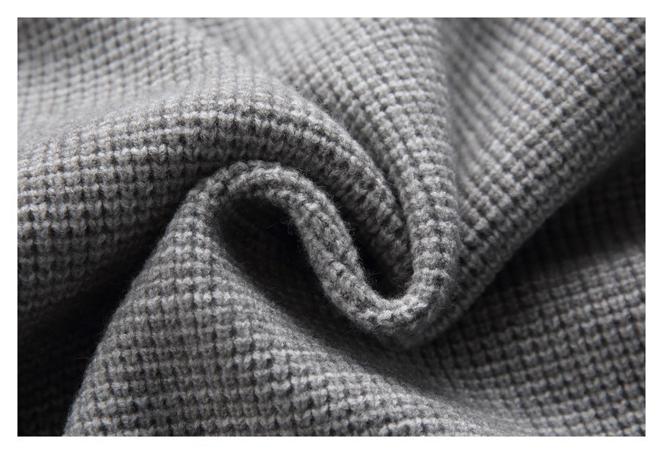 Close-up of gray textured fabric curled into a fold, showing its raised woven surface.