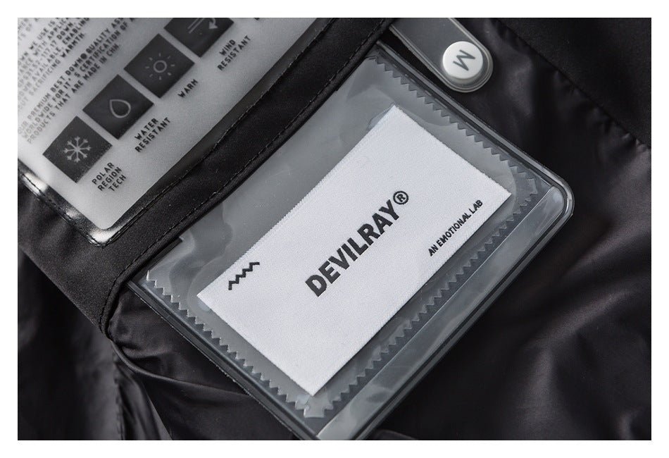 Close-up of a black garment with a clear pocket holding a white DEVRAY brand label.