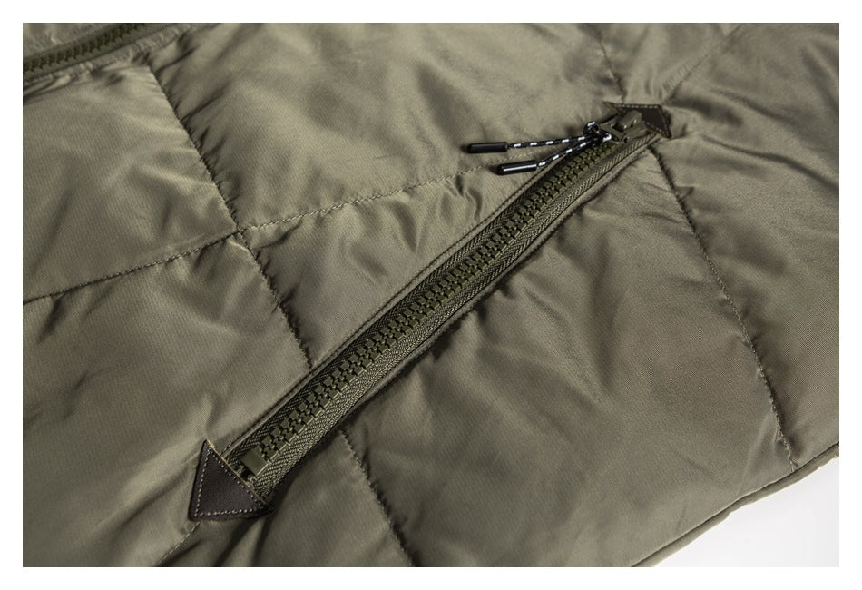 Diagonal zip pocket with corded pulls on an olive-gray padded jacket.