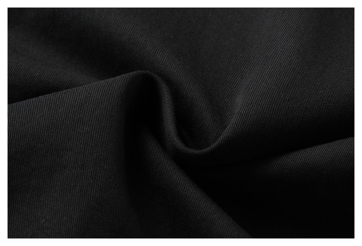 Close-up of black fabric draped into folds, showing its fine diagonal weave.