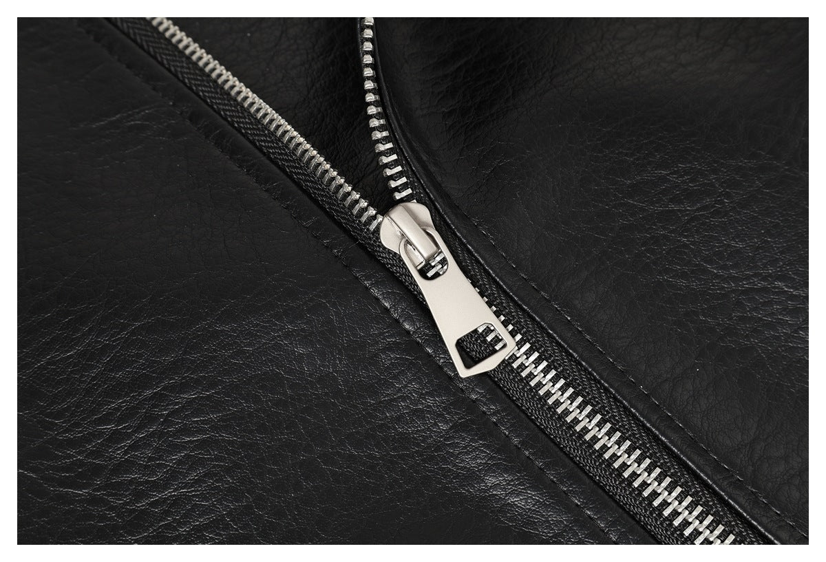 Close-up of a silver zipper pull and teeth against the textured black jacket.