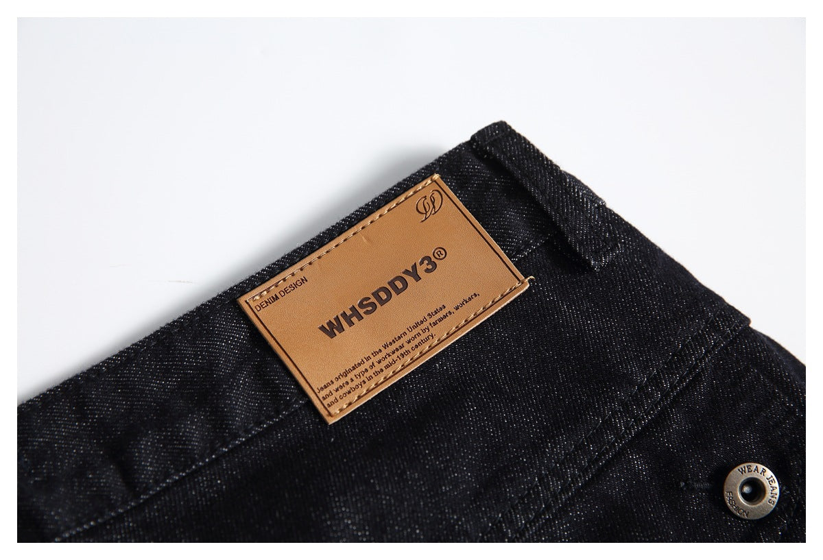 Close-up of a tan branded patch on the waistband of black jeans.