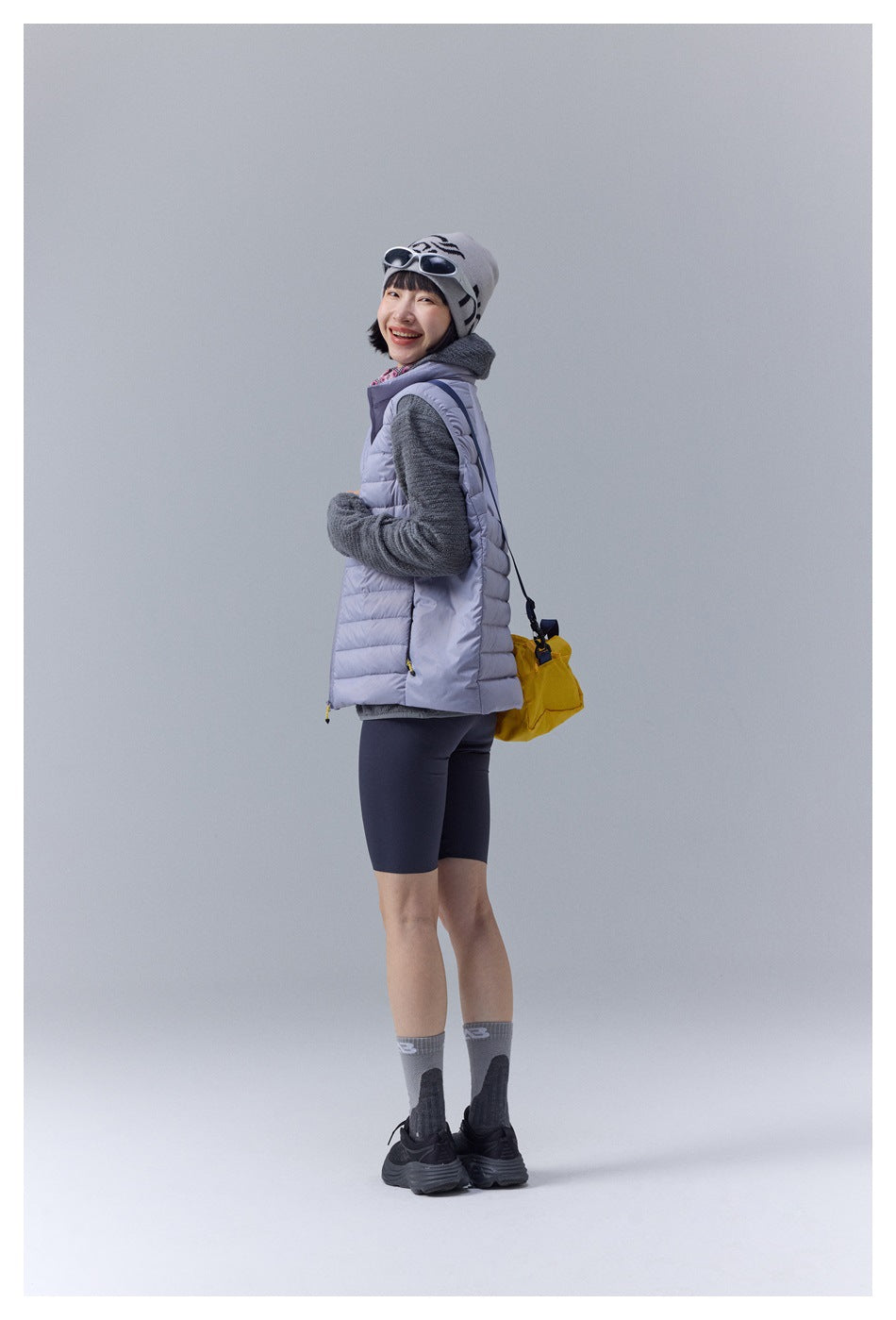 Model wearing a pale lavender quilted puffer vest, shown from a rear three-quarter angle.