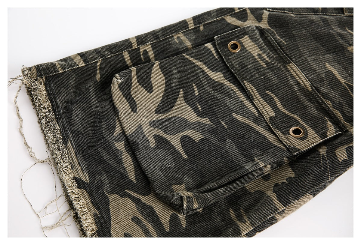 Close-up of a camouflage trouser pocket with an eyelet-detailed flap and frayed edge.