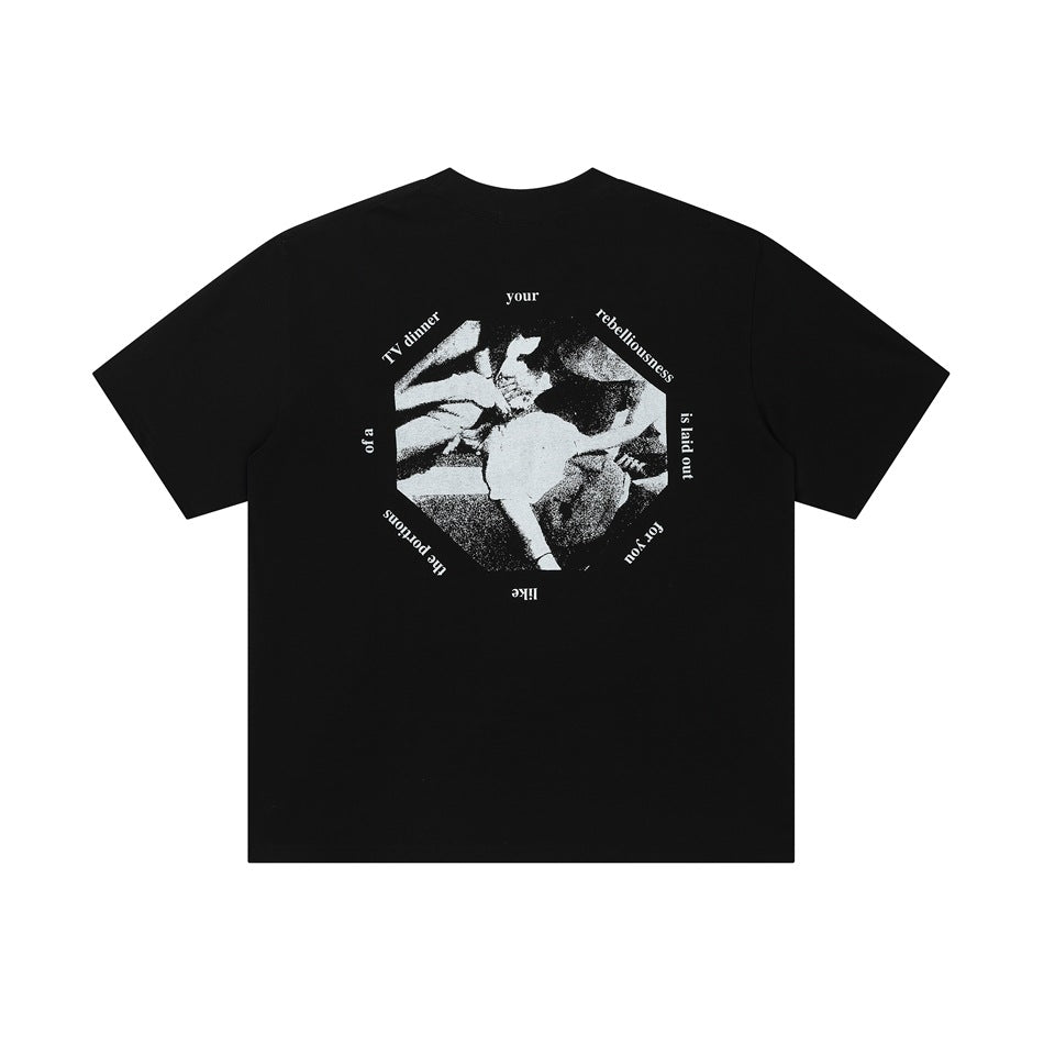 Back of black short-sleeve T-shirt with white octagonal photo graphic ringed by circular text, flat lay