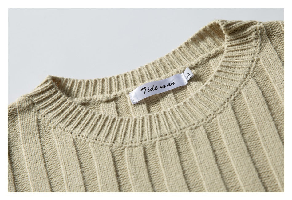 Close-up of a cream rib-knit sweater neckline and its sewn Tide man label.