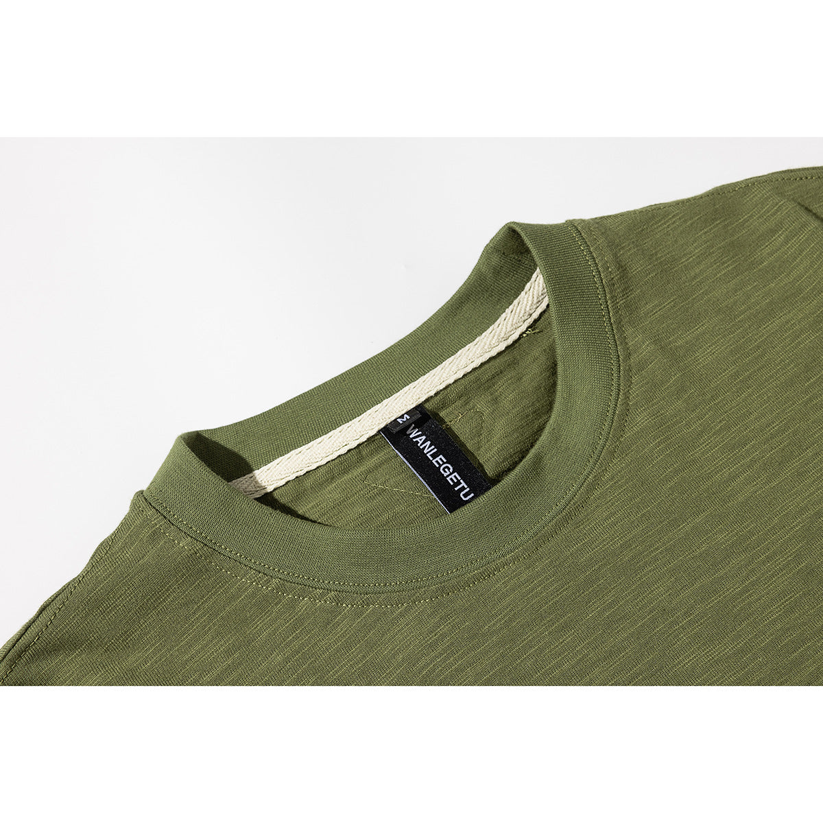 Close-up of an olive green T-shirt neckline, stitching, and black neck label.