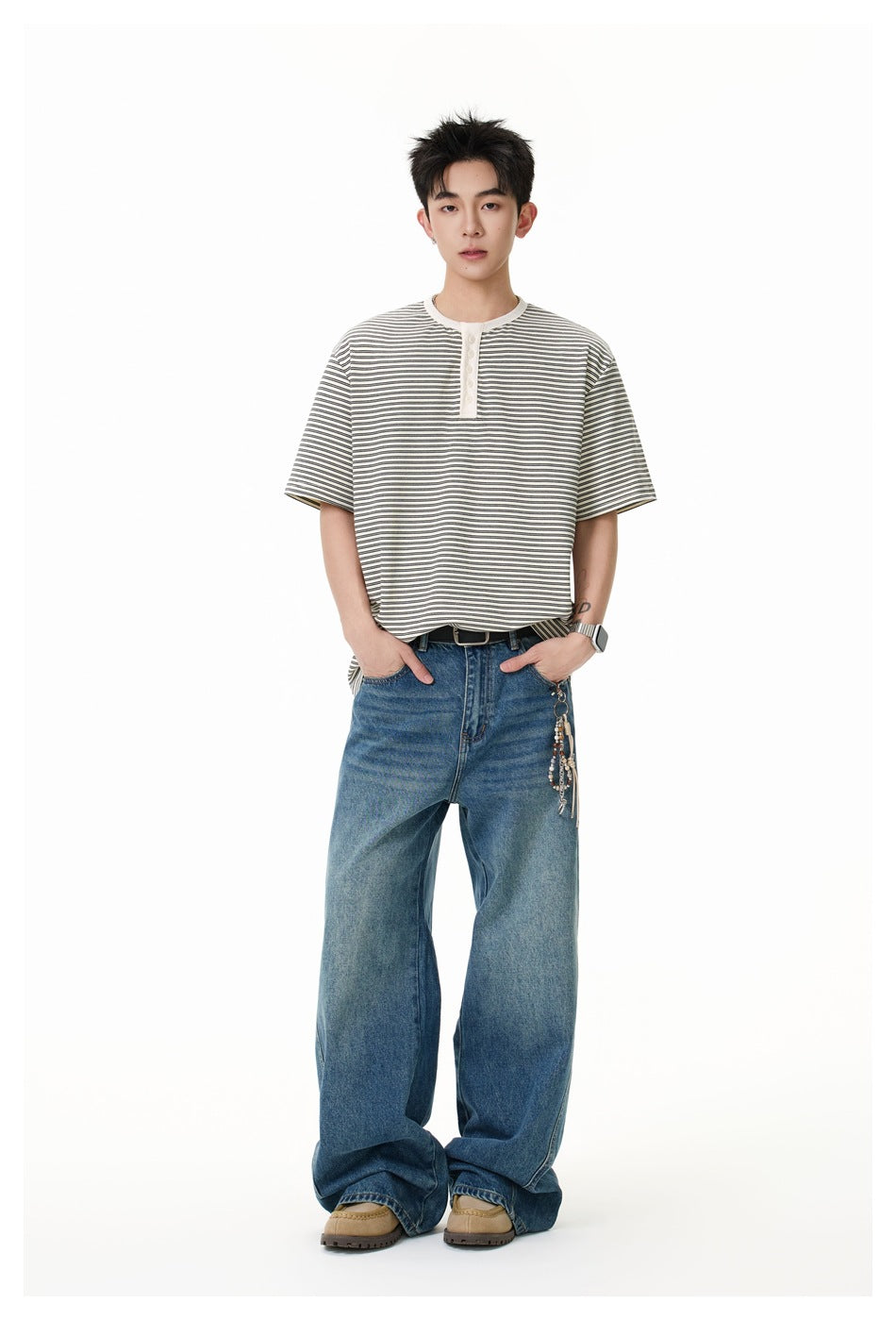 Model wearing a loose gray-and-white striped short-sleeve henley with blue wide-leg jeans.